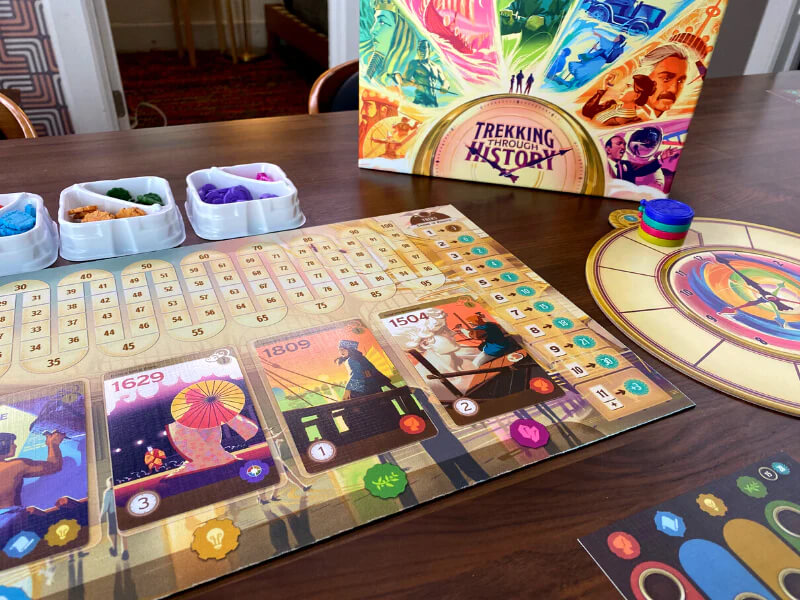 components from the Trekking Through History board game on a wooden table